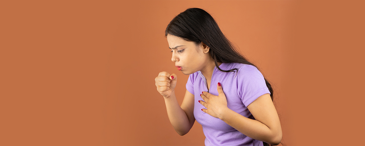 Person suffering from a sore throat and cough, holding their throat in discomfort.